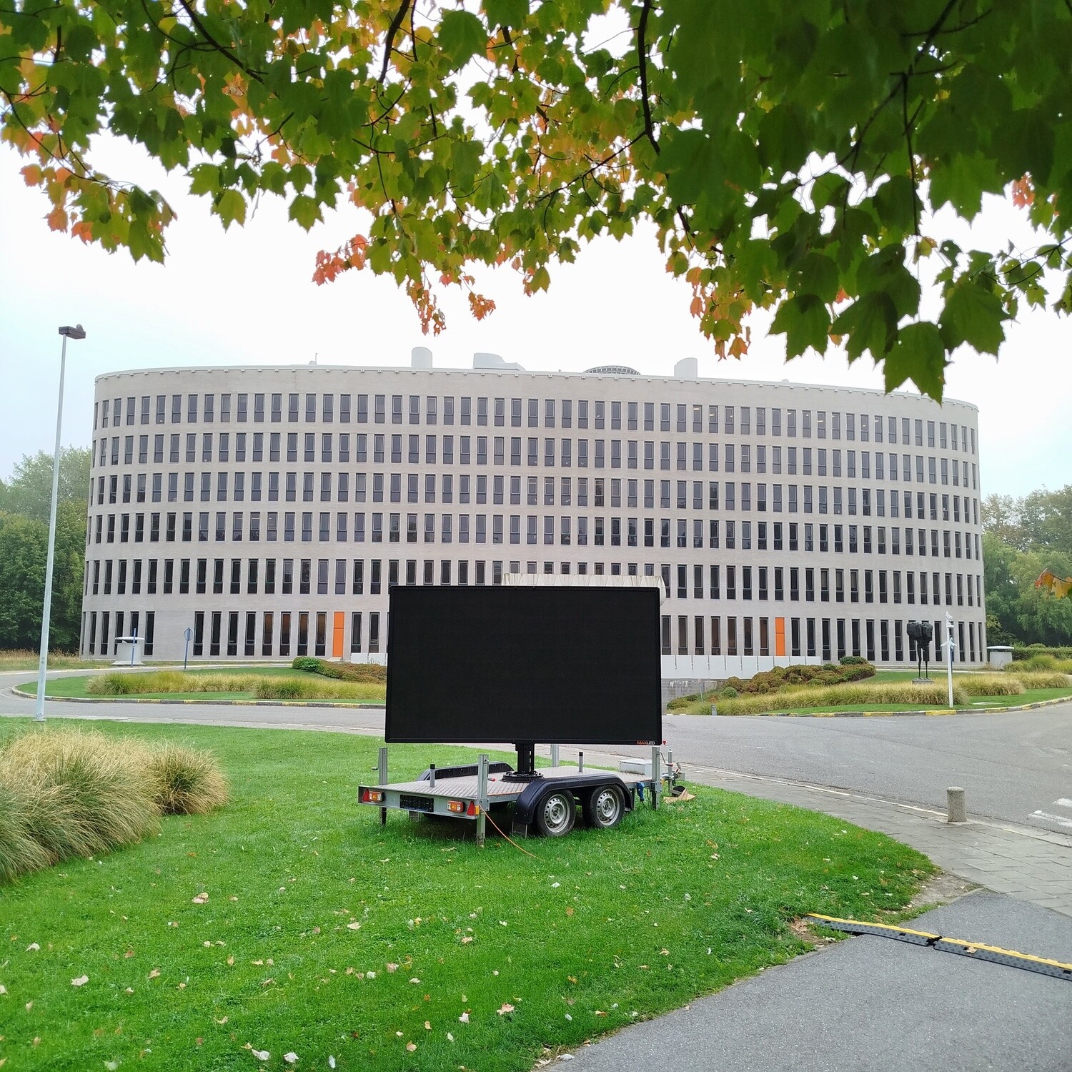 A big TV turned off on a cart and VUB Brussels University building in the background
