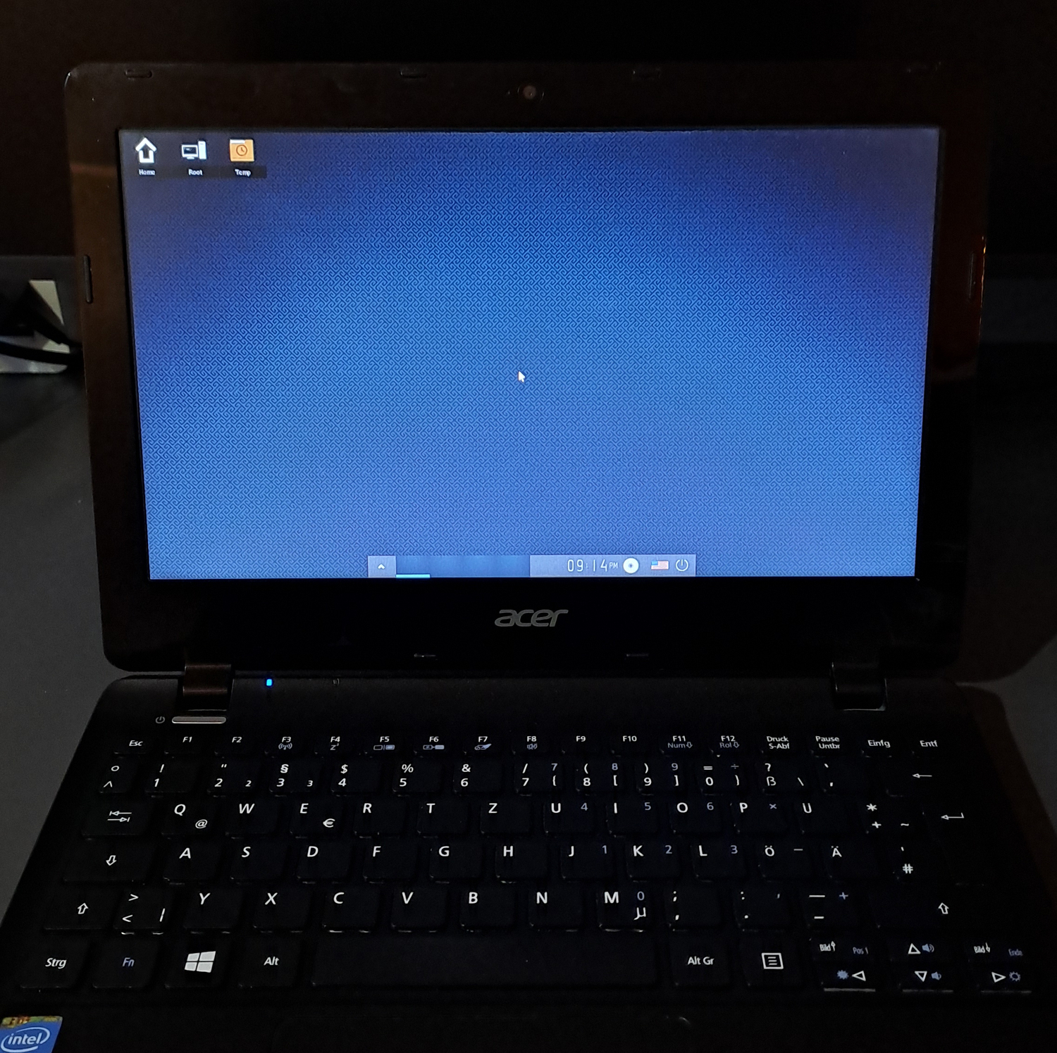 Photograph of a laptop showing Enlightenment desktop in the default configuration.