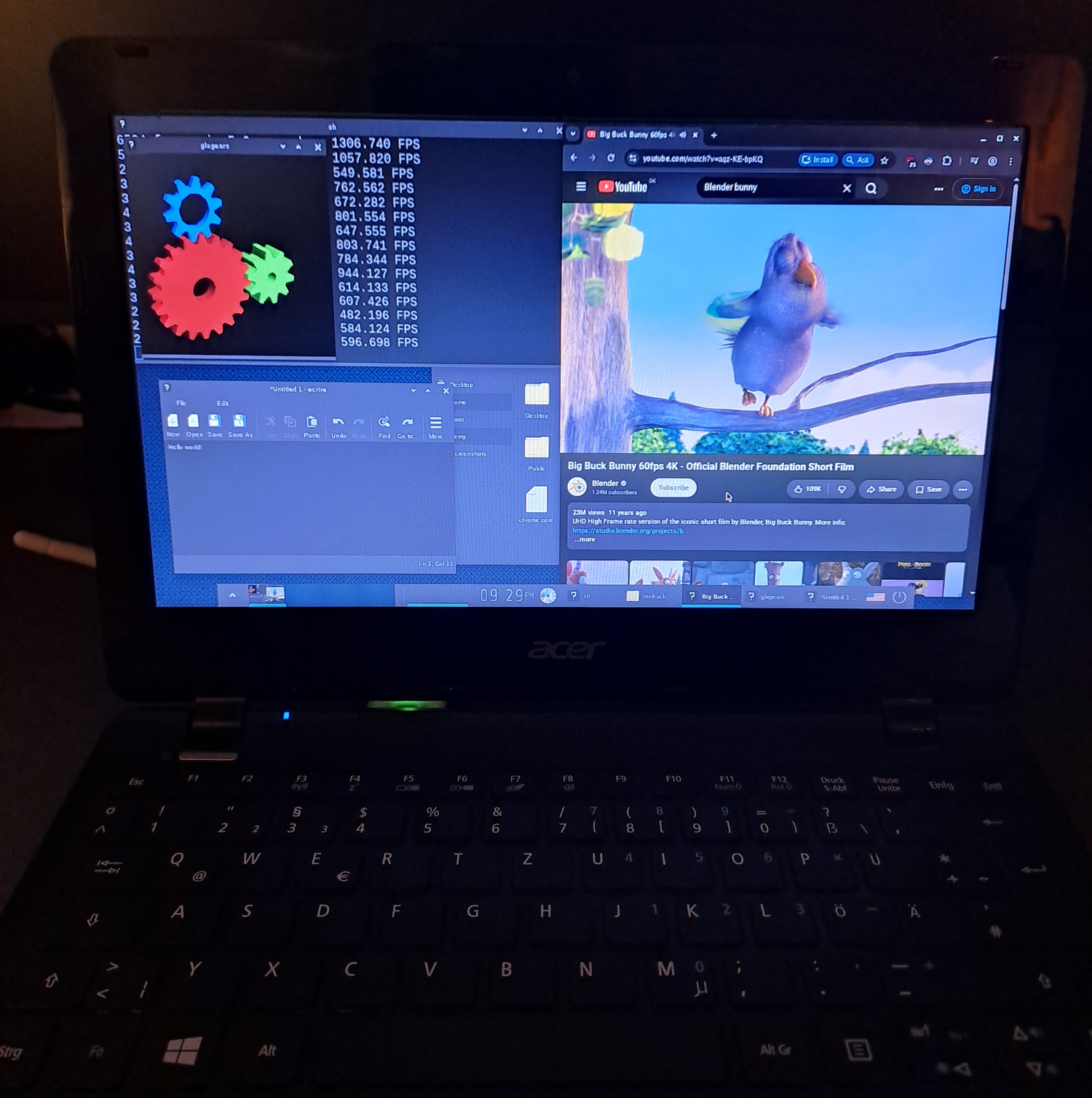 Photograph of a laptop showing Enlightenment desktop running Chromium, glxgears, Enlightenment's text editor (ecrire) and Enlightenment's file manager.